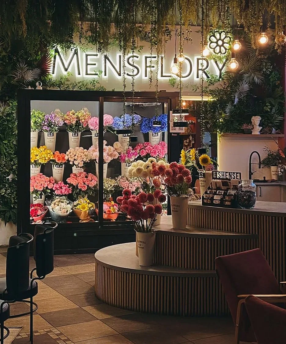 Cozy and vibrant flower shop interior with diverse floral arrangements and ambient lighting.